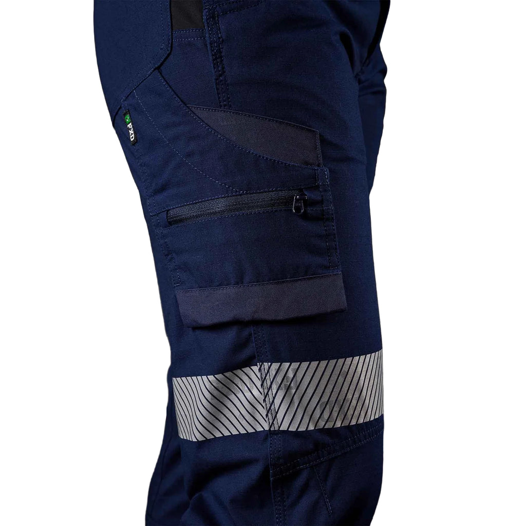 A close up view of the right side of the navy blue FXD Women's Taped Cargo Work Pants (WP-7WT) with reflective silver bands on the legs against a plain white background.