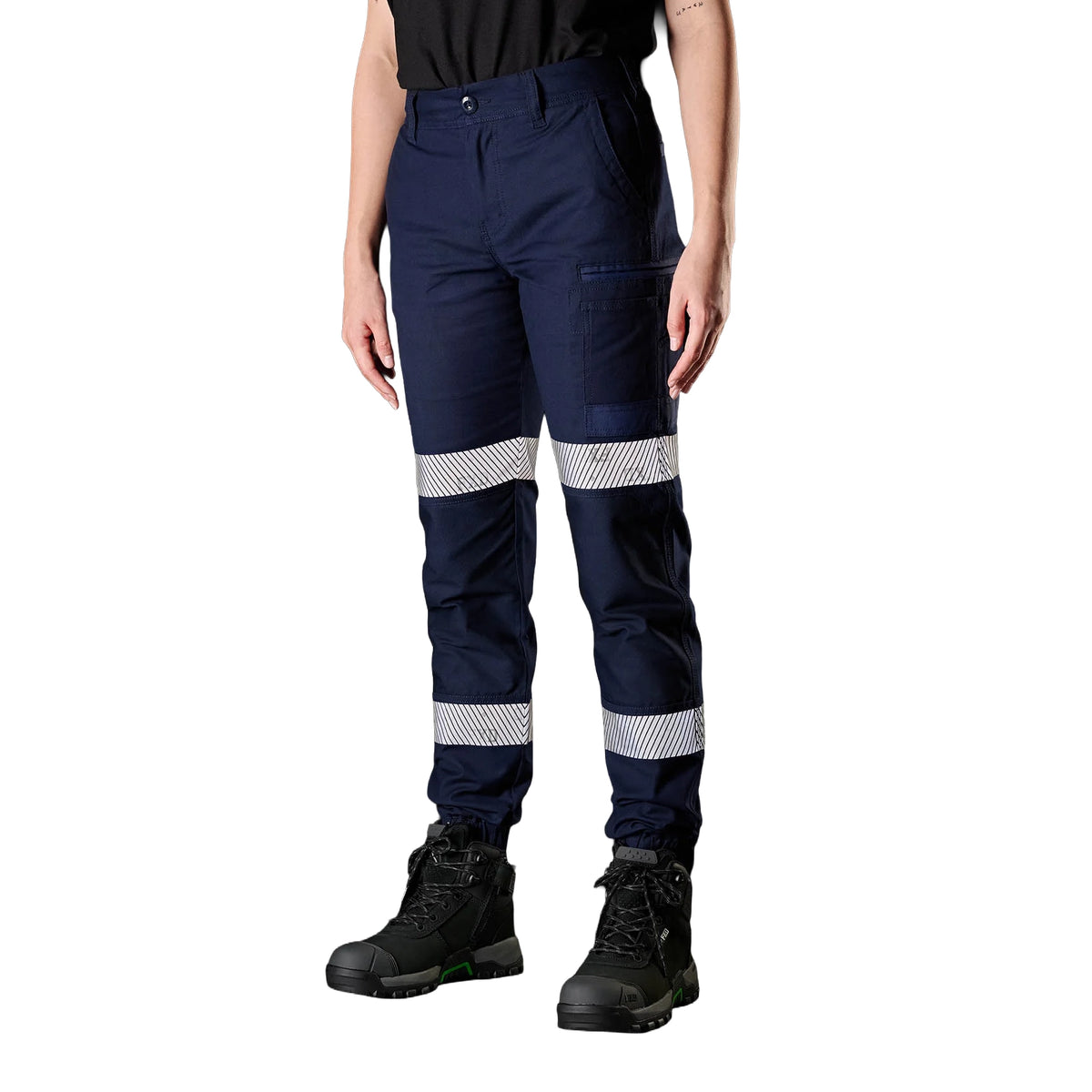 A woman wearing navy FXD Women's WP-4WT Reflective Cuffed Work Pants (FX12206208) with reflective silver stripes on the thighs and lower legs, paired with black boots against a plain white background.