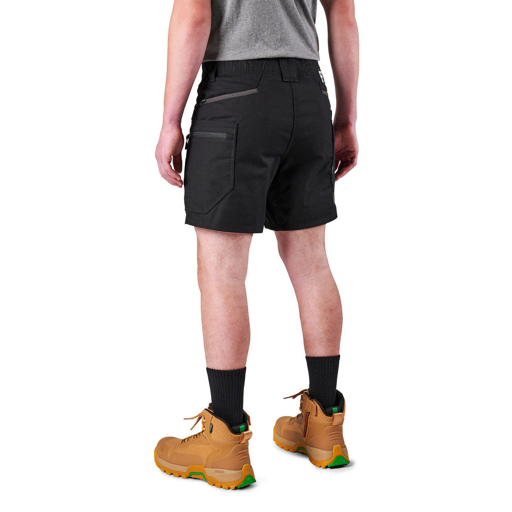 A model from the waist down wearing black FXD Men's WS-6 Work Shorts (FX02306021), black crew socks, and tan work boots against a plain white background.