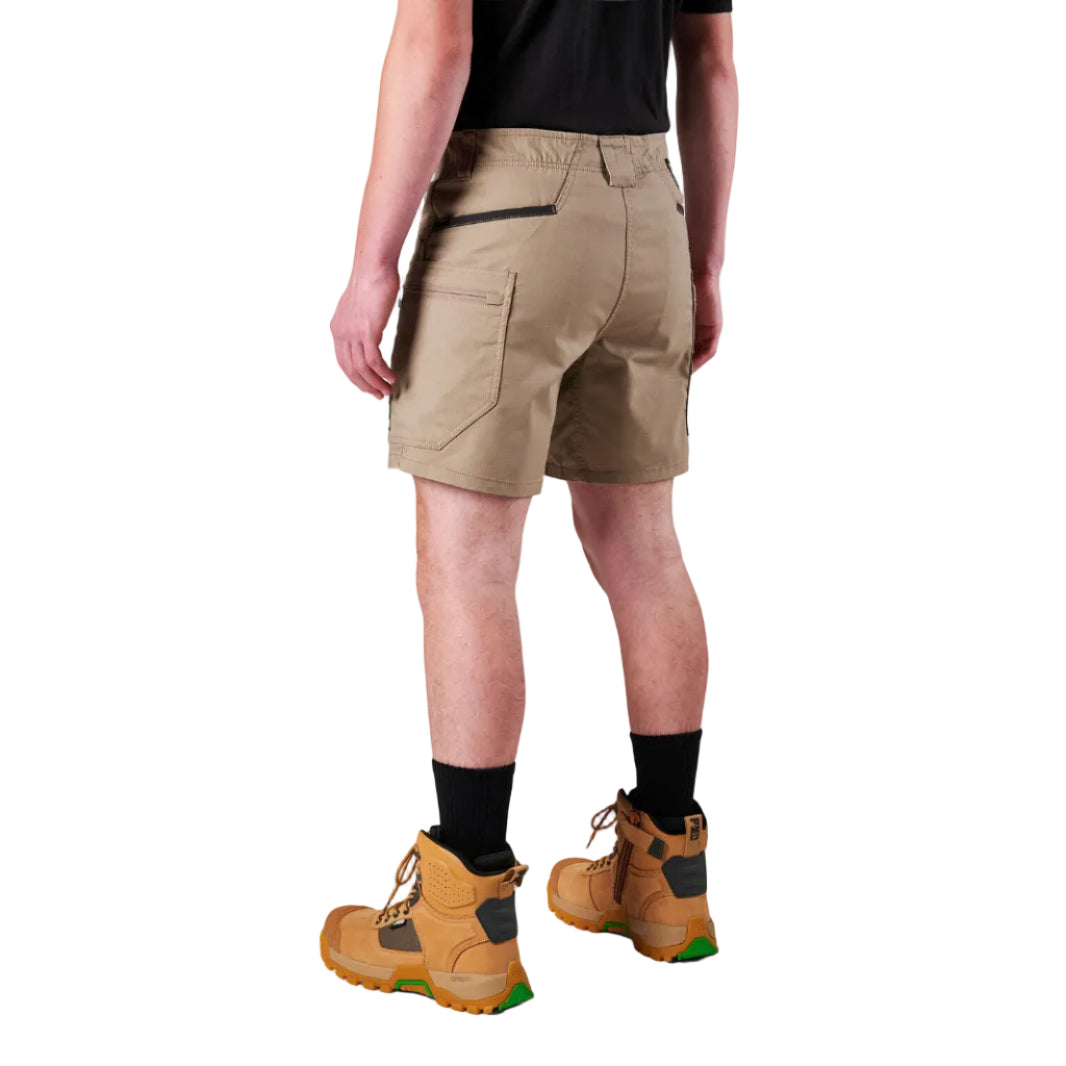 A model from the waist down wearing khaki FXD Men's WS-6 Work Shorts (FX02306021), a black tee, black crew socks, and tan work boots against a plain white background.