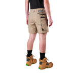 A model from the waist down wearing khaki FXD Men's WS-6 Work Shorts (FX02306021), a black tee, black crew socks, and tan work boots against a plain white background.