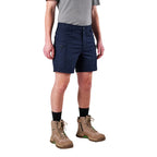 A model from the waist down wearing navy FXD Men's WS-6 Work Shorts (FX02306021), a grey tee, black crew socks, and tan work boots against a plain white background.