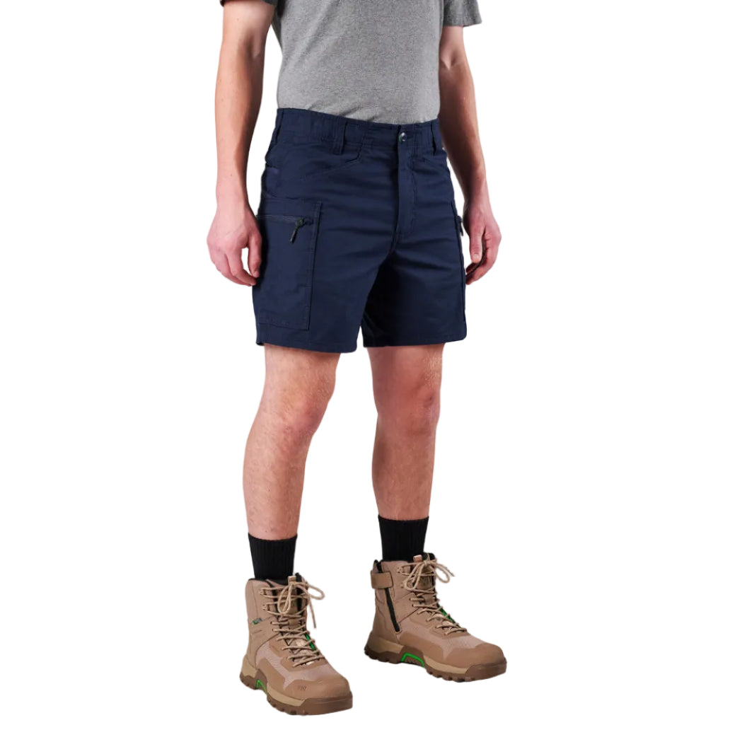 A model from the waist down wearing navy FXD Men's WS-6 Work Shorts (FX02306021), a grey tee, black crew socks, and tan work boots against a plain white background.