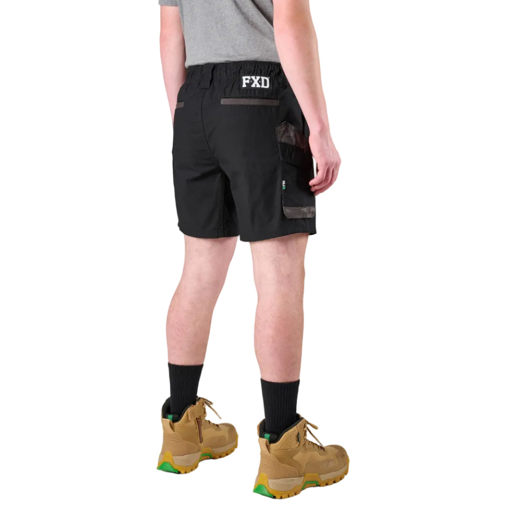 A man modelling black FXD Men's WS-7 Work Shorts (FX02306022) with a grey tee, black crew socks and wheat coloured boots on a white background.