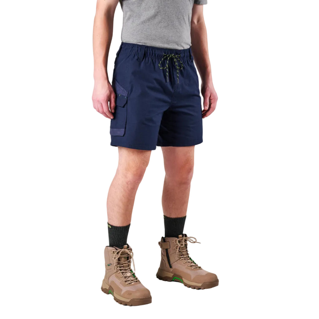 A man modelling navy FXD Men's WS-7 Work Shorts (FX02306022) with a grey tee, black crew socks and stone coloured boots on a white background.