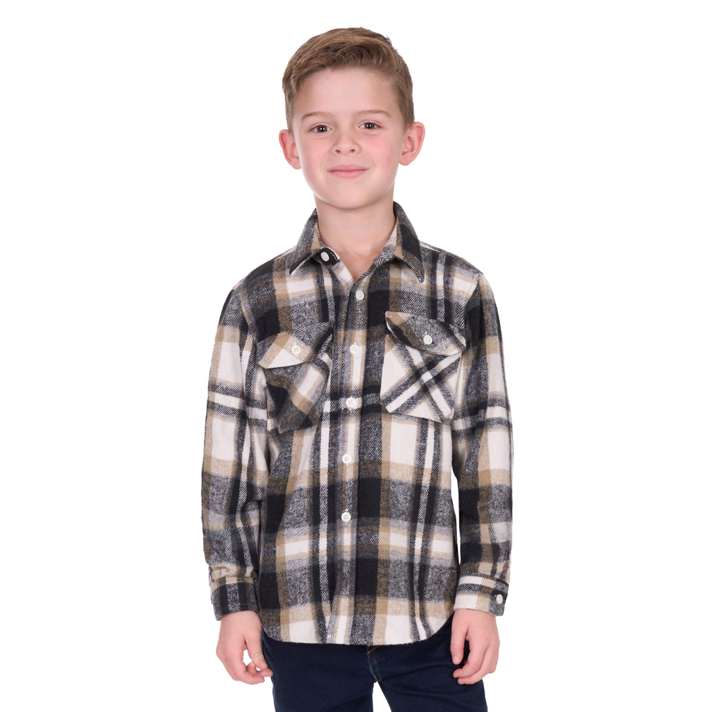 A young boy with short hair smiles at the camera, wearing the Hard Slog Childrens King L/S Thermal Shirt (H6W7115207) in Black/Tan checks and dark pants, standing against a white background.