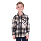 A young boy with short hair smiles at the camera, wearing the Hard Slog Childrens King L/S Thermal Shirt (H6W7115207) in Black/Tan checks and dark pants, standing against a white background.