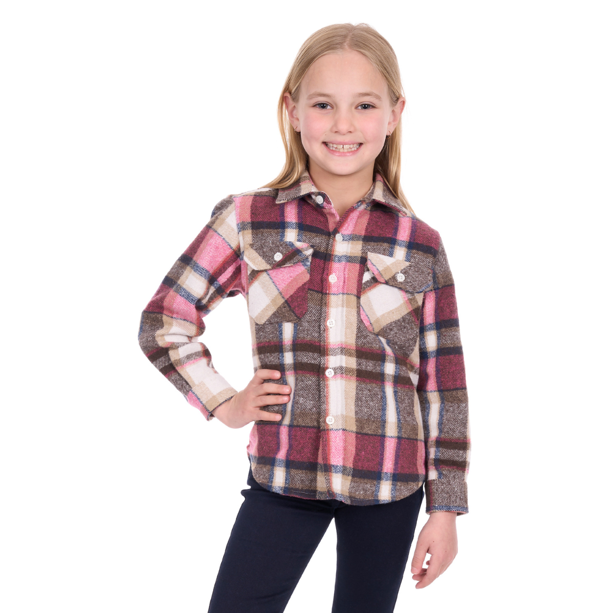A smiling young girl with blonde hair stands with one hand on her hip, wearing the Hard Slog Childrens Ori Thermal L/S Shirt (H6W7115194) in Pink/Tan and dark pants, set against a white background.