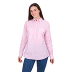 A woman wears the Hard Slog Womens Clara Half Button L/S Shirt in pink with blue jeans, smiling against a plain white background.
