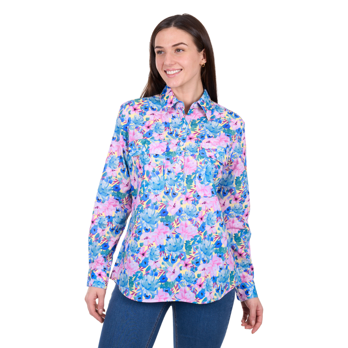 A woman smiles and poses in a Hard Slog Womens Trixie Half Button L/S Shirt (H6W2101172) in Blue/Multi floral print, paired with blue jeans, against a white background.