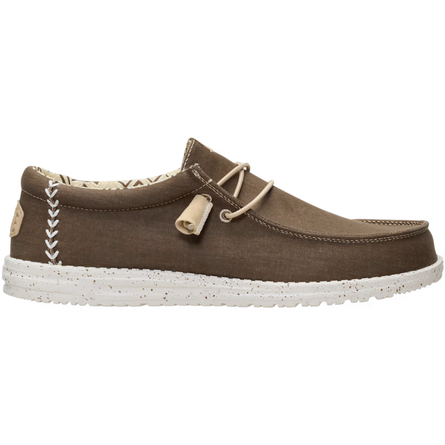 Hey Dude Mens Wally Stretch Canvas Slip On Shoes (40700-2LN) in Teak Brown feature an easy-on lace system, white stitching, cushioned ankle collar, patterned lining, and a white speckled sole. Shown on a plain background.