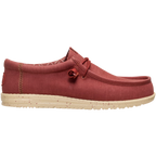 The Hey Dude Mens Wally Stretch Canvas Slip On Shoes in Burnt Red/Boulder Tan feature a red stretch canvas upper, beige speckled sole, visible stitching, cushioned ankle collar, and lace detail near the collar. Brand: Hey Dude.