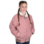 A young girl with braided hair smiles as she stands with hands in her pockets, wearing the Just Country Childrens Diamantina Sherpa Corduroy Jacket (BWOJ2600) in Dusty Pink, featuring a white sherpa collar and heavy-duty zips, against a white background.