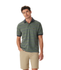 A man wears the R.M.Williams Mens Brunswick Stripe Polo (KP210QS09) in Spruce Green, styled with tan shorts and a dark collar, standing against a white background. Shop online from an official R.M.Williams retailer.