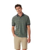 A man wears the R.M.Williams Mens Brunswick Stripe Polo (KP210QS09) in Spruce Green, styled with tan shorts and a dark collar, standing against a white background. Shop online from an official R.M.Williams retailer.