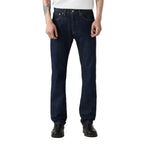 A person wearing Levi's Men's 501 Original Straight Fit Jeans (00501-0115) with a white t-shirt and black boots, shown from the waist down on a solid white background.