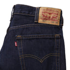 A close up of the waist of a pair of dark blue rinse Levi's Men's 517 Heritage Bootcut Jeans (00517-0216), against a solid white background.