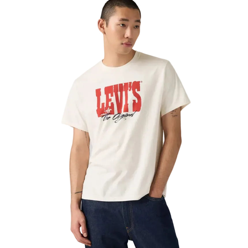 A person wearing a Levi's Mens Graphic S/S Tee (16143-2381) The Original 1 Egret and dark jeans stands against a plain white background, looking slightly to the side with one hand in their pocket.