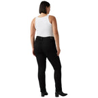 A woman shown from the back wearing black slim-fit jeans, a white sleeveless top, and black ankle boots against a white studio background.