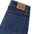 Close-up of the back waistband and pocket area of Levi's blue denim jeans, showing the tan leather brand patch and the red Levi's tab on a white background.