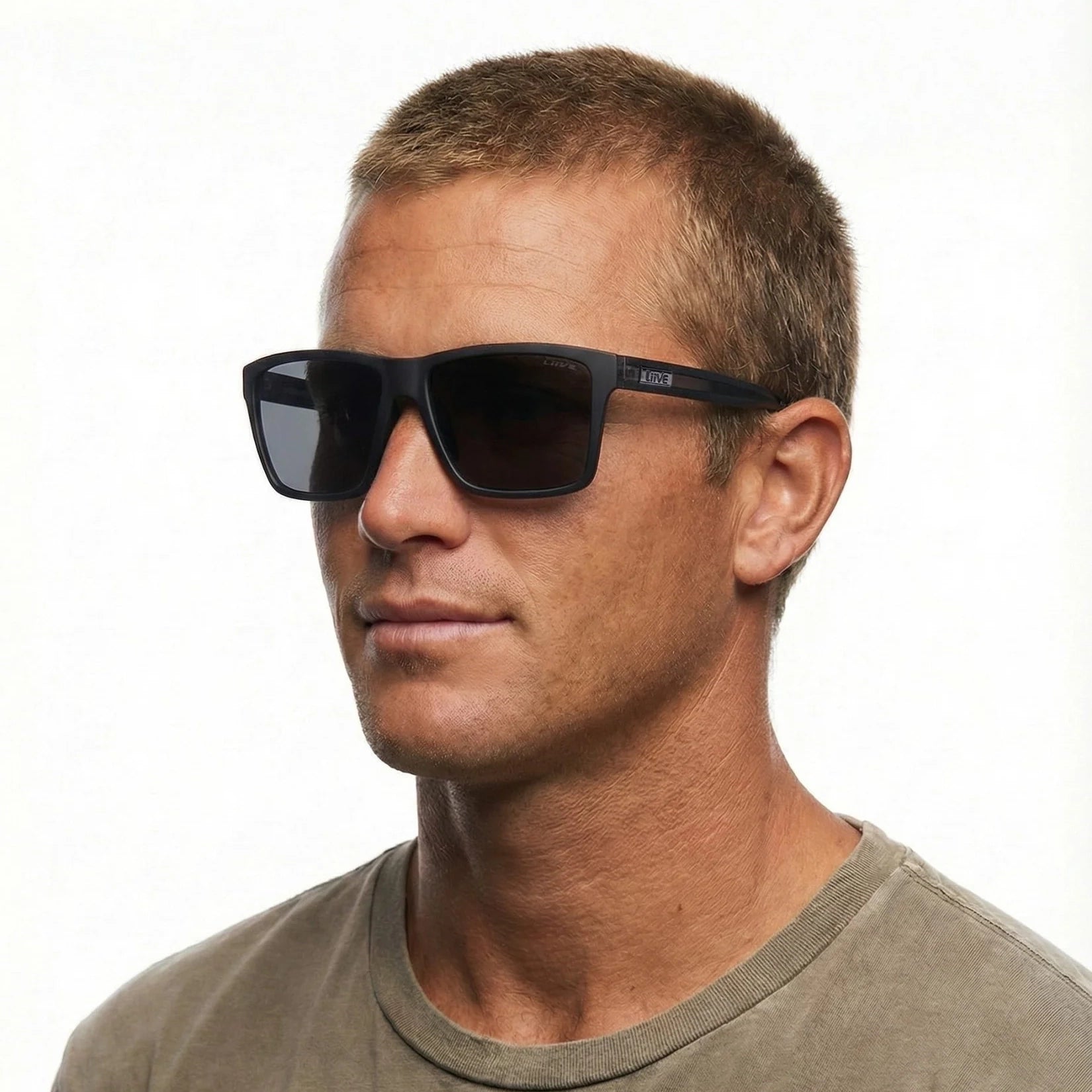 Headshot of a man modelling a pair of Liive Vision Bazza Sunglasses (L0670A) with matte black frames and smoke lenses, shown on a white background.