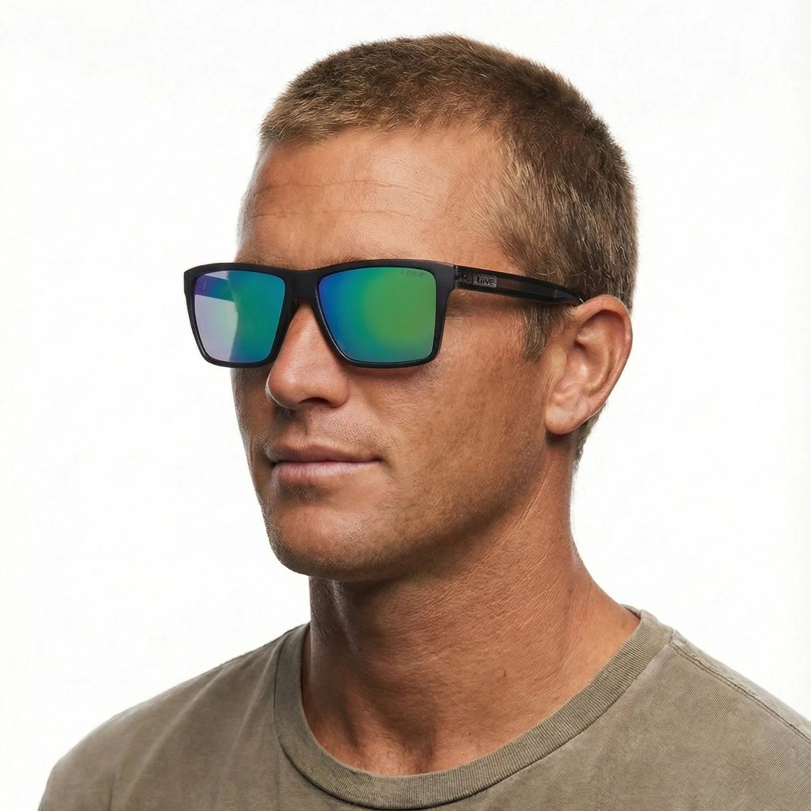 A headshot of a man modelling a pair of Liive Vision Bazza Sunglasses (L0671A) with a matte black frame and green mirrored lenses, shown against a plain white background.