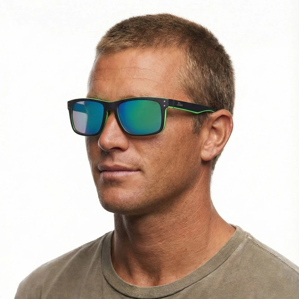 A man modelling Liive Vision Cheap Thrill Sunglasses (L0356K) in matte black with vibrant lime green accents along the temples and lower rims, and mirrored green lenses on a white background.
