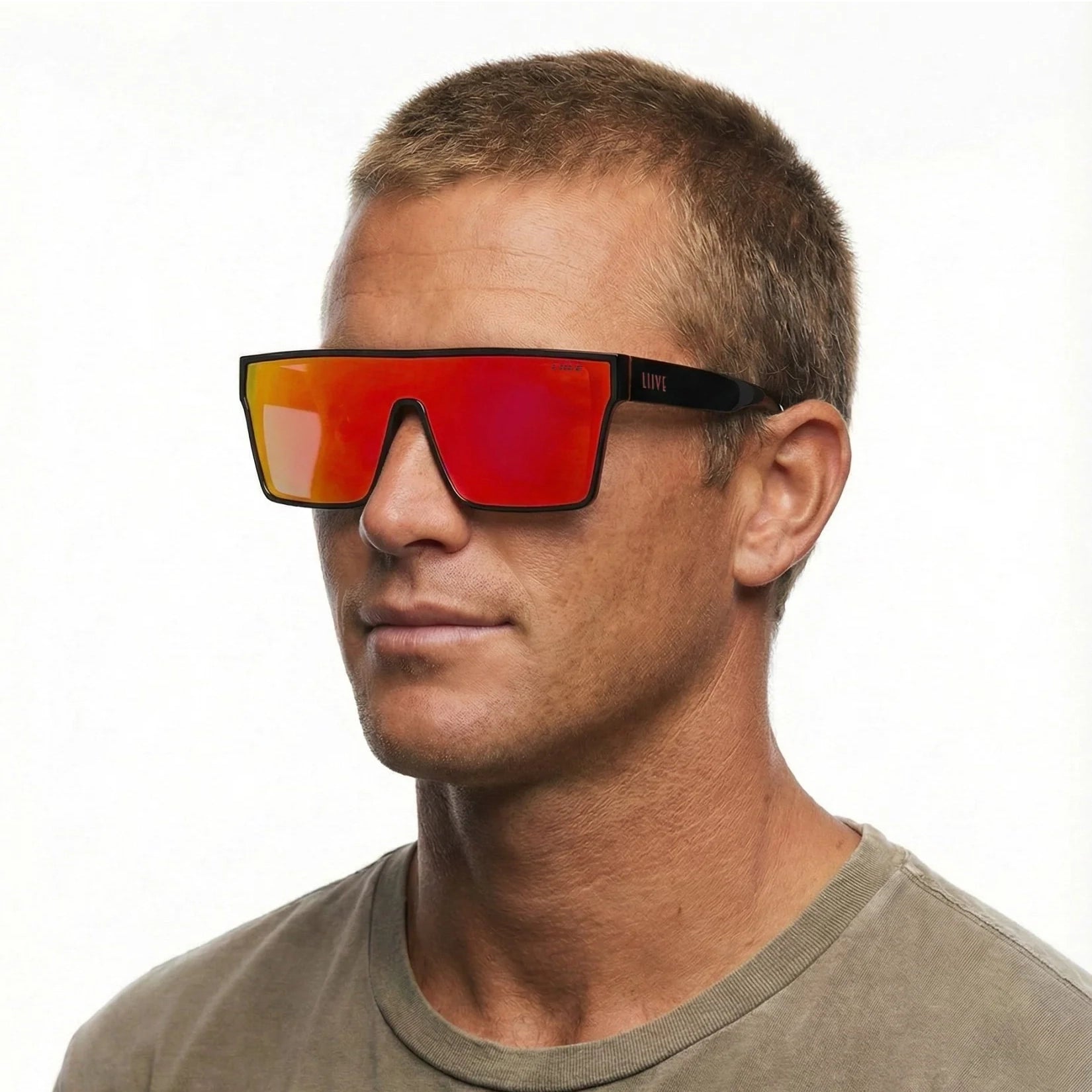 A headshot of a man modelling a pair of Liive Vision Wasteland Sunglasses (L0828A) with red mirror lenses and black and red frames, on a white background.