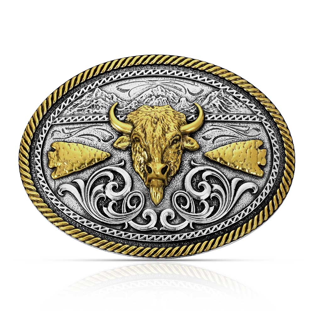 The Montana Silversmiths Attitude Buckle (A1066P) Buffalo showcases an ornate oval design with a gold bull head centerpiece, gold arrowheads, engraved silver Montana Armor background, scrollwork accents, and a twisted gold border.