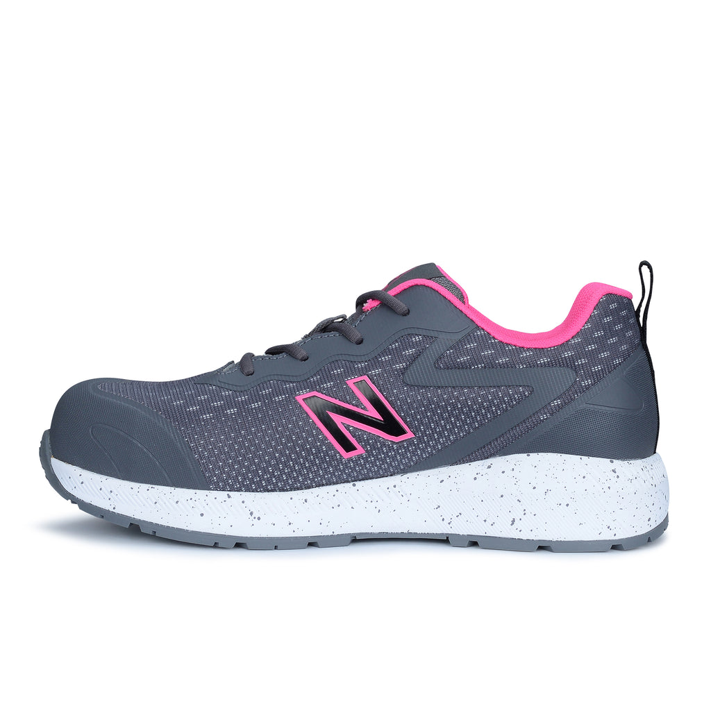 Side view of a grey and pink New Balance Women's Logic Composite Toe Sneaker style Shoe (WIDLOGI) with pink accents and logo detail on a white background.