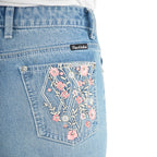 Close up of the back pocket detail of a pair of light blue denim Pure Western High Rise Flora Bootcut Jeans (PCP2213725), against a white background.