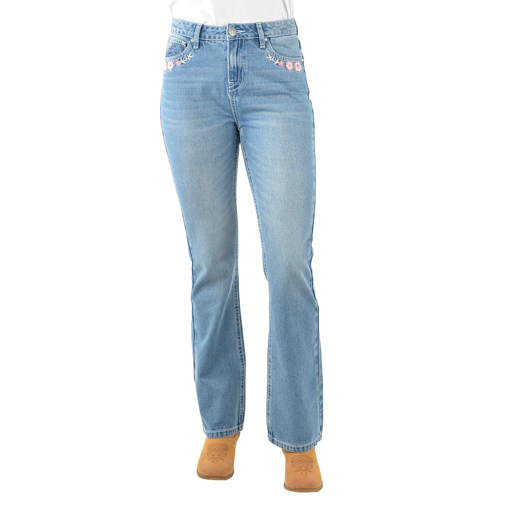 Front view of a pair of light blue denim Pure Western High Rise Flora Bootcut Jeans (PCP2213725) with floral embroidery on the front pockets, worn by a model with brown heels against a white background.