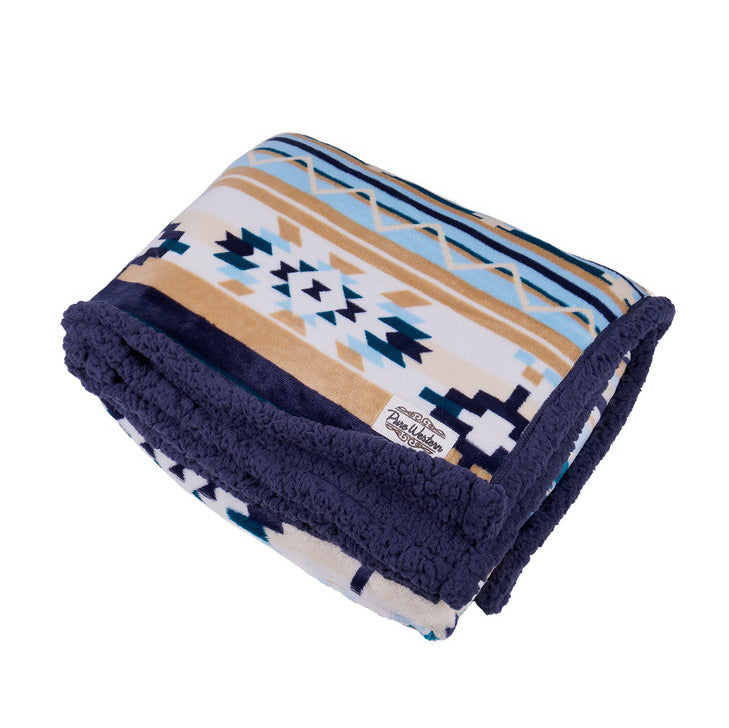 The Pure Western Aztec Print Snuggle Rug (P6W2975RUG) in Natural/Blue features a blue, beige, and white Southwestern pattern with a soft dark blue sherpa plush lining. Made from 100% polyester with a small fabric label on one corner.