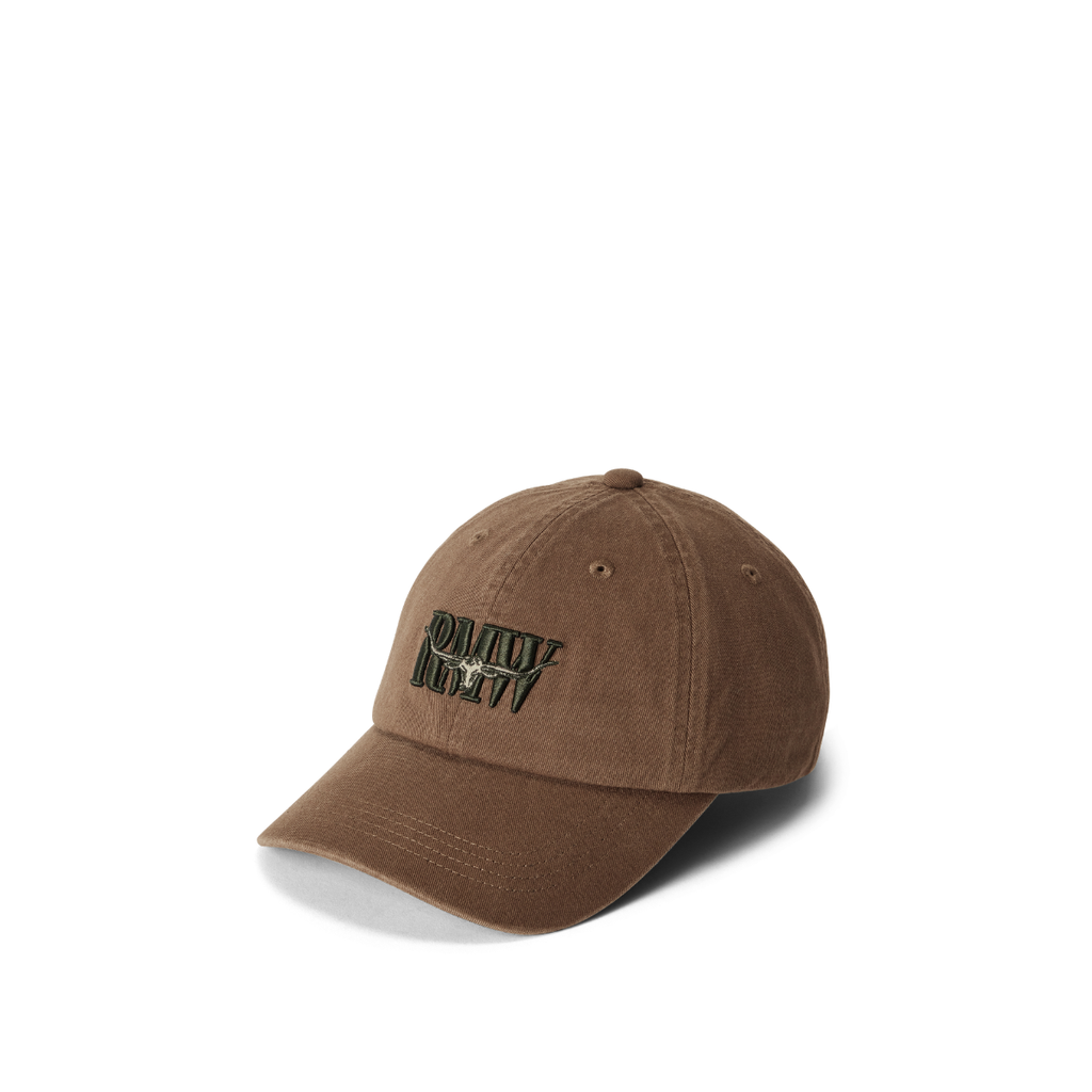 The R.M.Williams Heritage Twill Cap (ACX9OWI27) in Cigar features a curved brim, green and black embroidered "RALLY CREW" text, and Heritage logo on the front, shown on a white background.