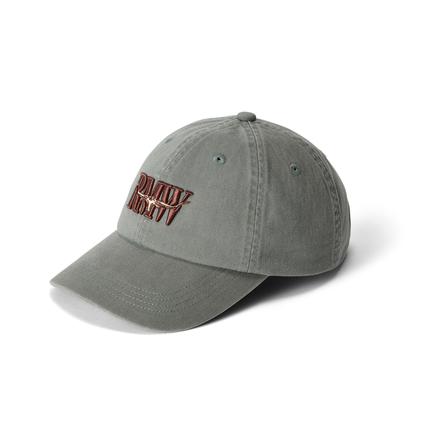 The R.M.Williams Heritage Twill Cap (ACX9OWI27) in slate is made from organic cotton twill and features embroidered red and white "DAILY REVV" text on the front, shown against a white background.