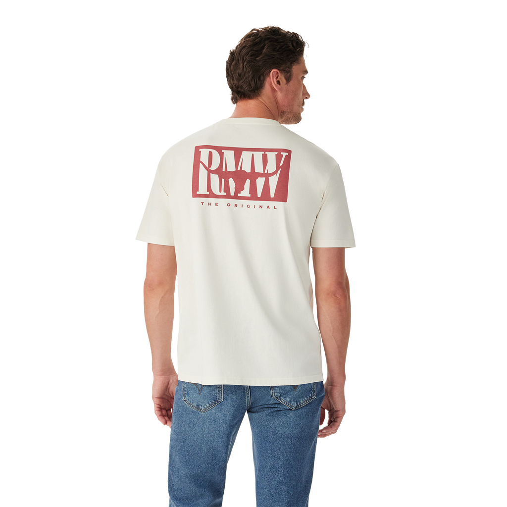 A man in blue jeans stands with his back to the camera, wearing the R.M.Williams Mens Branded S/S Tee (KDU10JE07) in white, featuring a large red "RMW THE ORIGINAL" logo on the back, against a plain white background.