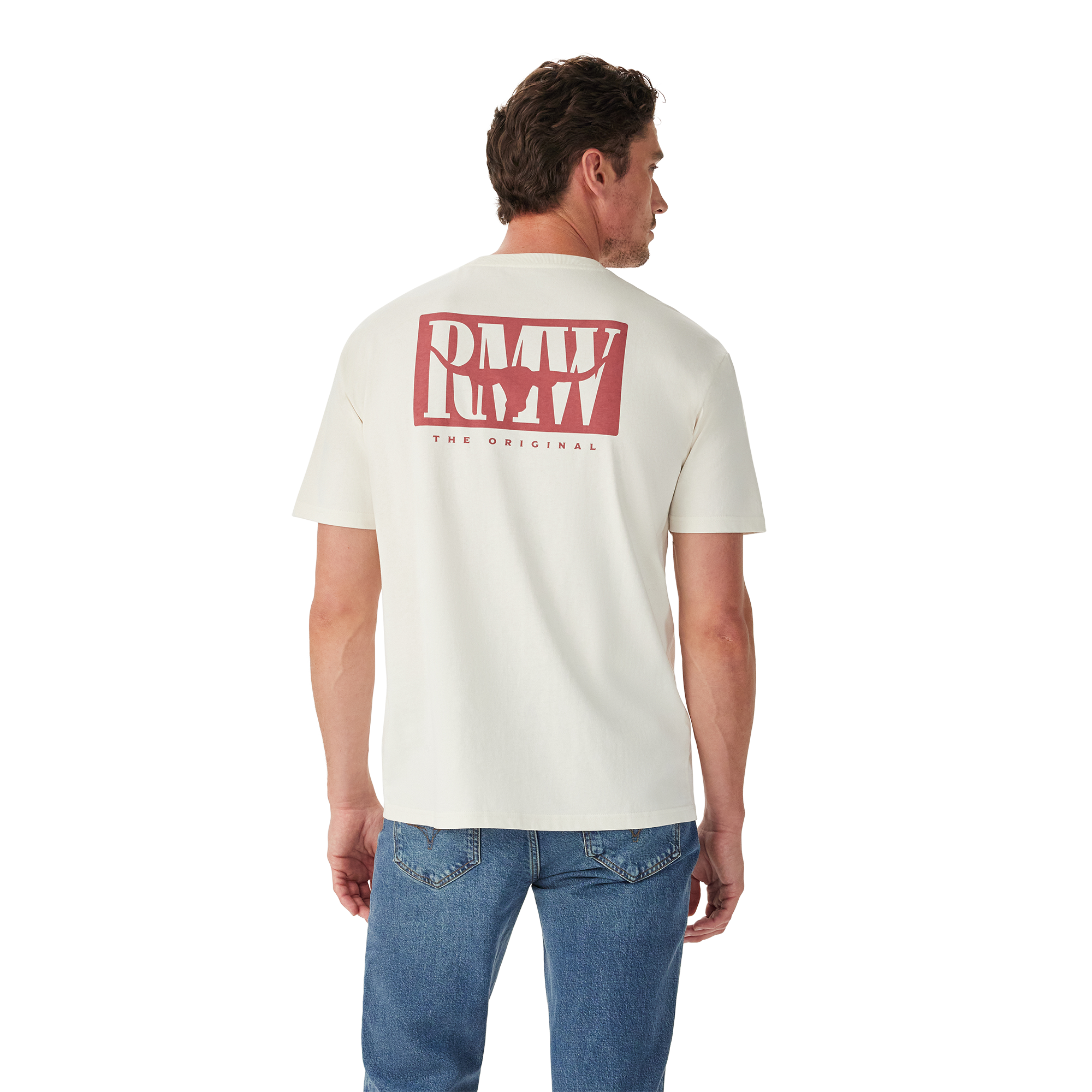 A man in blue jeans stands with his back to the camera, wearing the R.M.Williams Mens Branded S/S Tee (KDU10JE07) in white, featuring a large red "RMW THE ORIGINAL" logo on the back, against a plain white background.