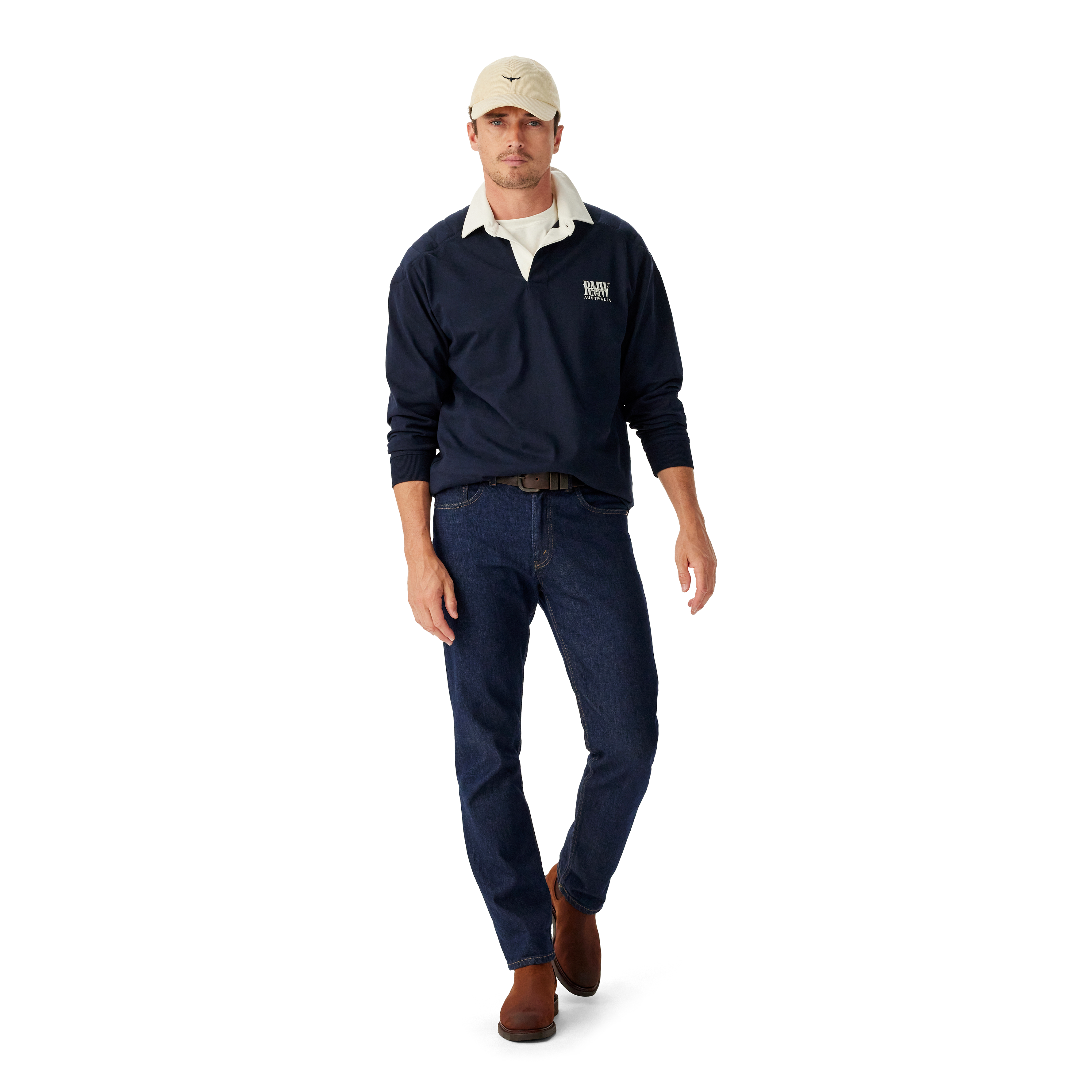 Man wearing a navy R.M.Williams Classic Shoulder Rugby with an R.M.Williams logo, beige cap, brown leather belt, brown boots and dark jeans on a white background.  R.M.Williams Mens Classic Shoulder Rugby (KR200RJ4502) Navy