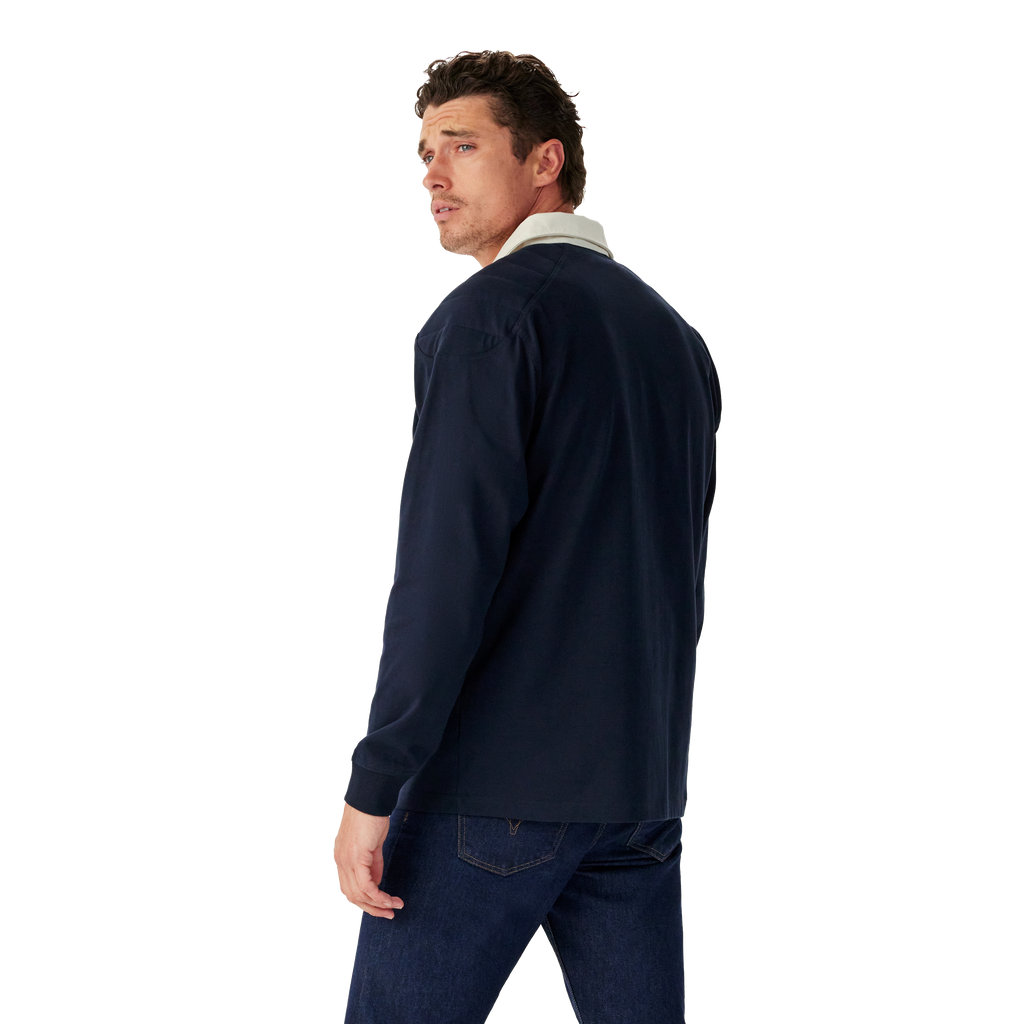 Man wearing a navy R.M.Williams Classic Shoulder Rugby and dark jeans on a white background. R.M.Williams Mens Classic Shoulder Rugby (KR200RJ4502) Navy