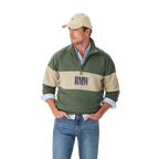 A man in a beige cap, blue jeans, and a light blue shirt layered under the R.M.Williams Mens Heritage 1/4 Zip Sweatshirt (KZU00BB02) in Spruce Green stands with his hands in his pockets against a plain white background.
