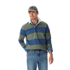 A man wearing an R.M.Williams Mens Jones Stripe Rugby (KR200RJ16) in Ensign Blue, a gray cap, and blue jeans stands with one hand in his pocket against a plain white background.