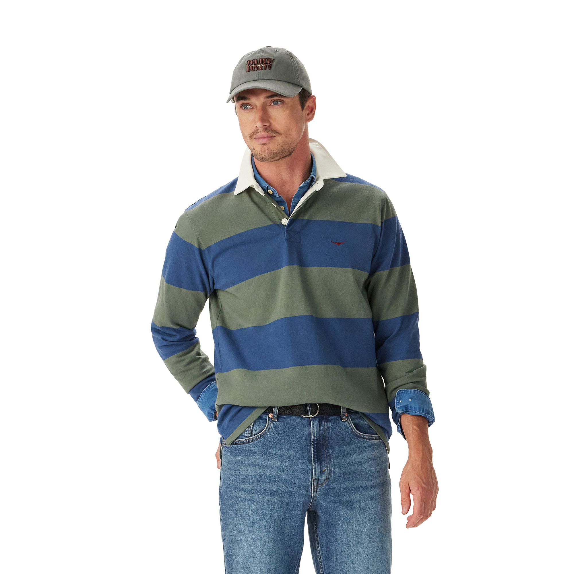 A man wearing an R.M.Williams Mens Jones Stripe Rugby (KR200RJ16) in Ensign Blue, a gray cap, and blue jeans stands with one hand in his pocket against a plain white background.