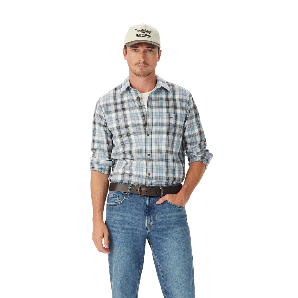 A man in a light baseball cap, blue jeans, brown belt, and an R.M.Williams Mens O'Connell Check L/S Shirt (SH201BS02) White stands with one hand in his pocket against a plain white background.
