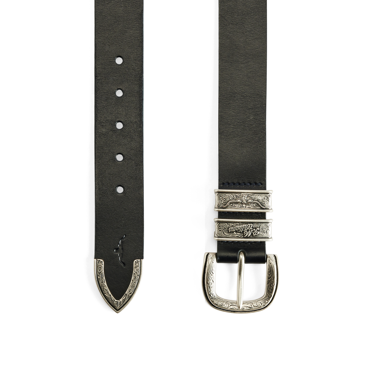 Flat lay of the engraved and embossed silver toned buckle, keepers and tail of a black R.M.Williams Western Drover Belt (BSF5DCH02) on a white background.