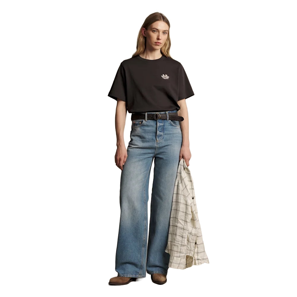 A woman wearing a dark chocolate R.M.Williams Kandos Short Sleeve Tee (KDX10JE06) with an RMW logo on the left chest, paired with denim jeans and a plaited leather belt, photographed on a white background.