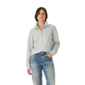 A woman with straight brown hair and a neutral expression wears the R.M.Williams Womens Trickett 1/4 Zip Sweatshirt (Salt) and blue jeans, standing against a plain white background with one hand in her pocket.