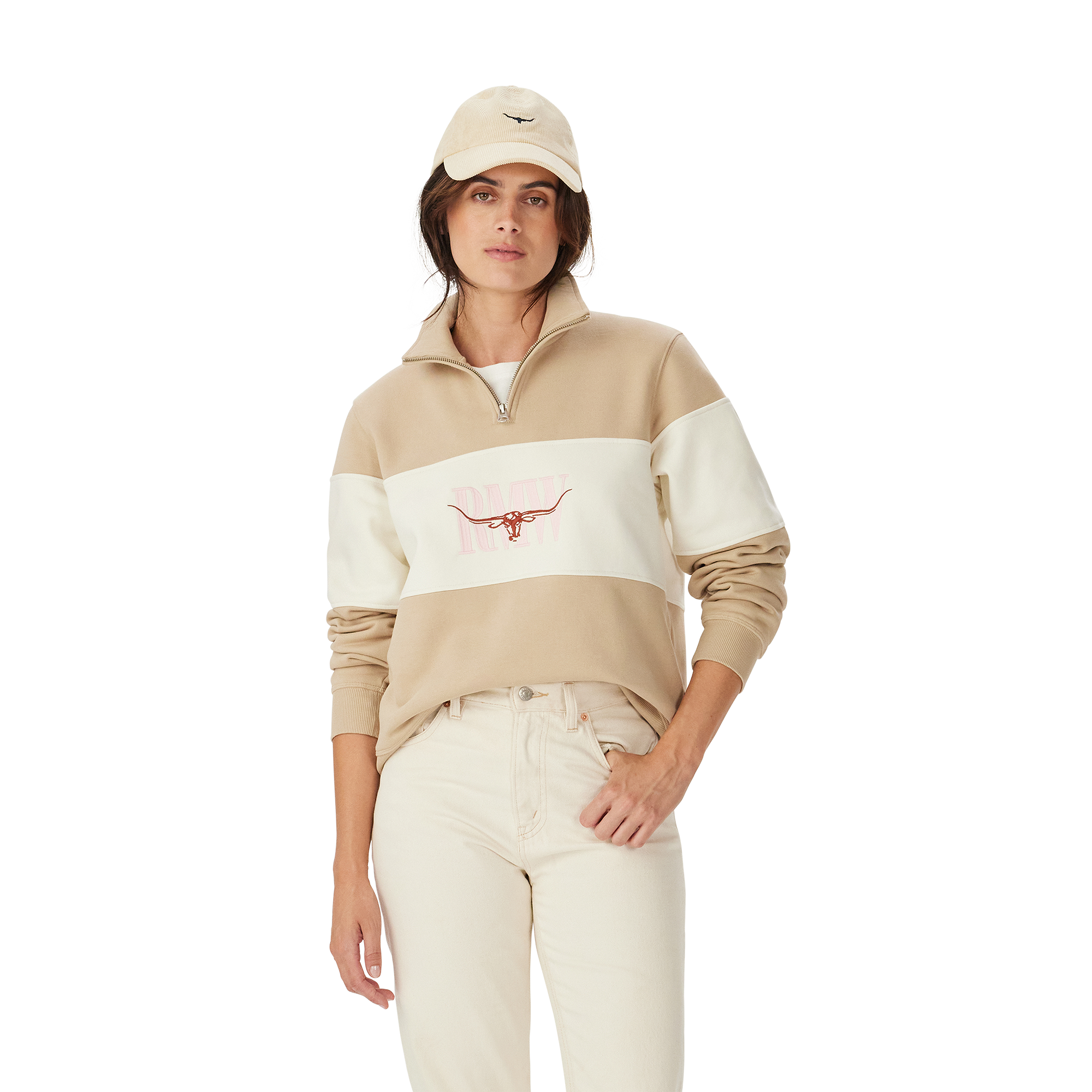 A woman in a beige cap, light jeans, and an R.M.Williams Womens Trickett Panel Sweatshirt (KZR00BB01) Sand stands against a plain white background.