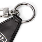 Close up detail of a black leather R.M.Williams Men's Keyfob (CKS4MLE03) with metal ring and clip on a white background.