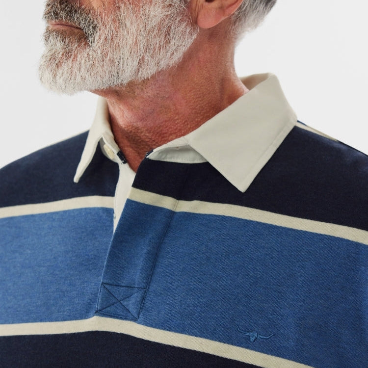 Close-up of a man wearing a blue, navy and white striped R.M.Williams Men's Tweedale Rugby (KR200JSFW01) on a white background.