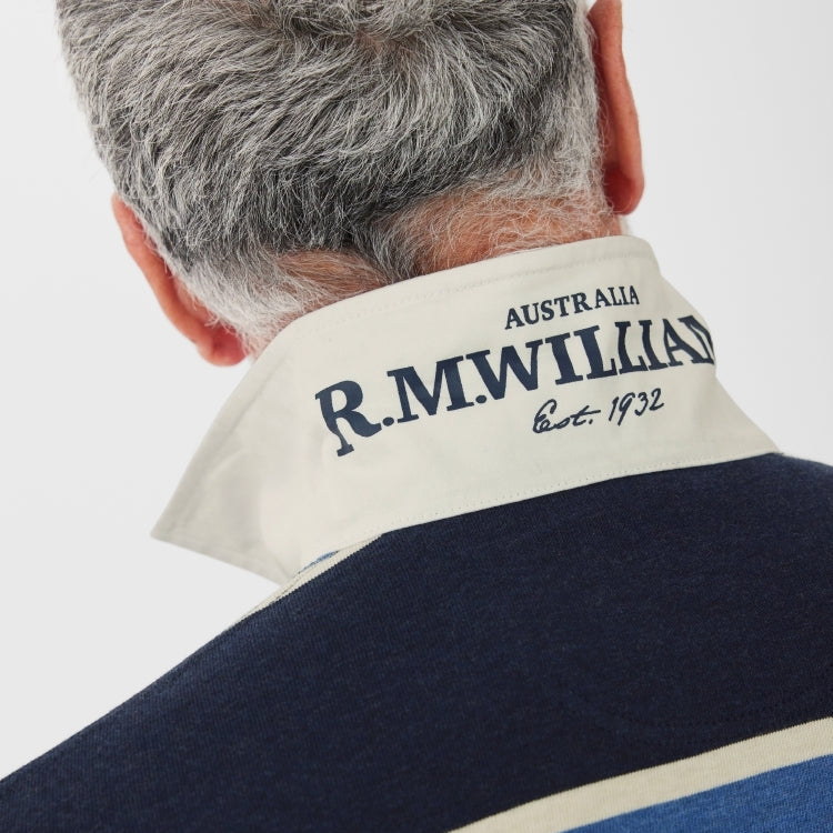 A close up, back view of a man wearing a blue, navy and white striped R.M.Williams Men's Tweedale Rugby (KR200JSFW01) on a white background.
